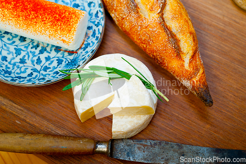 Image of French cheese and fresh  baguette on a wood cutter