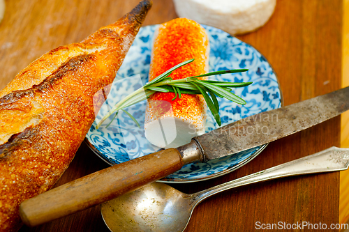 Image of French cheese and fresh  baguette on a wood cutter