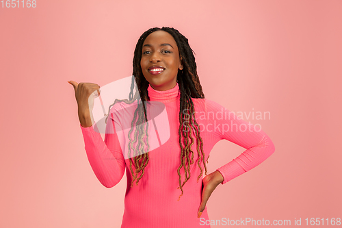 Image of Portrait of young african-american woman isolated on pink studio background, facial expression. Beautiful female half-lenght portrait with copyspace.