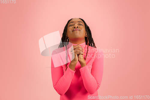 Image of Young emotional african-american woman isolated on pink studio background, facial expression. Half-lenght portrait with copyspace.