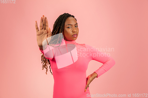 Image of Portrait of young african-american woman isolated on pink studio background, facial expression. Beautiful female half-lenght portrait with copyspace.