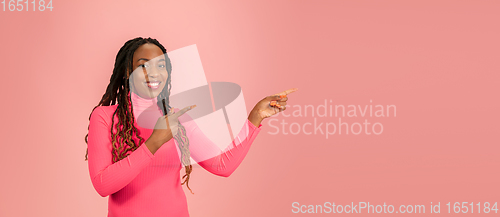 Image of Portrait of young african-american woman isolated on pink studio background, facial expression. Beautiful female half-lenght portrait with copyspace.