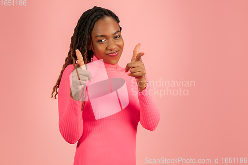 Image of Portrait of young african-american woman isolated on pink studio background, facial expression. Beautiful female half-lenght portrait with copyspace.