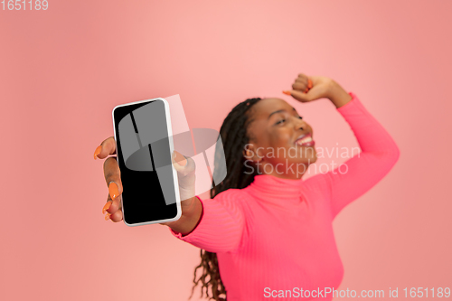 Image of Portrait of happy african-american woman isolated on pink studio background, facial expression. Half-lenght portrait with copyspace.