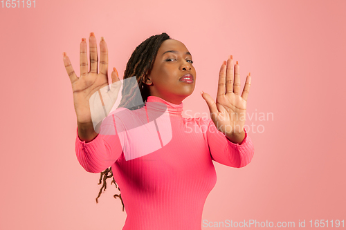 Image of Portrait of young african-american woman isolated on pink studio background, facial expression. Beautiful female half-lenght portrait with copyspace.