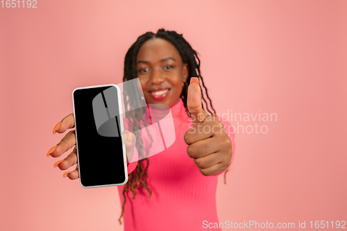 Image of Portrait of happy african-american woman isolated on pink studio background, facial expression. Half-lenght portrait with copyspace.