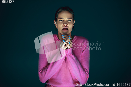 Image of Close up portrait of young crazy scared and shocked woman isolated on dark background