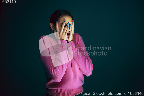 Image of Close up portrait of young crazy scared and shocked woman isolated on dark background