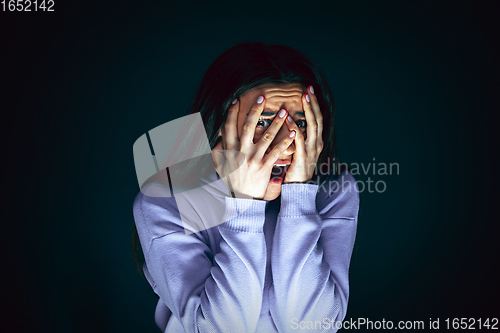 Image of Close up portrait of young crazy scared and shocked woman isolated on dark background