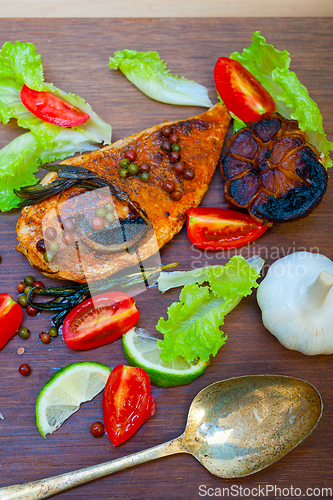 Image of wood fired hoven cooked chicken breast on wood board