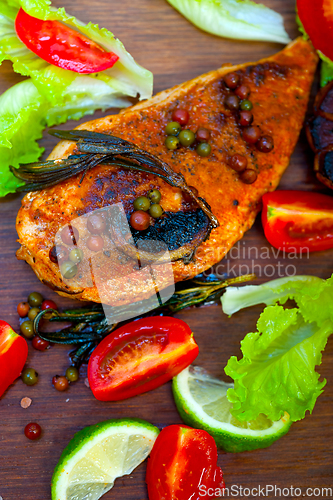 Image of wood fired hoven cooked chicken breast on wood board