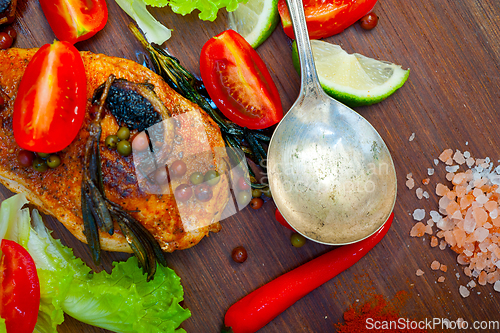 Image of wood fired hoven cooked chicken breast on wood board