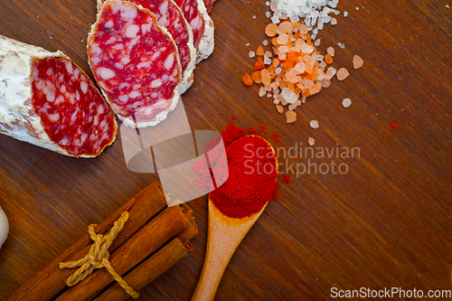 Image of traditional Italian salame cured sausage sliced on a wood board