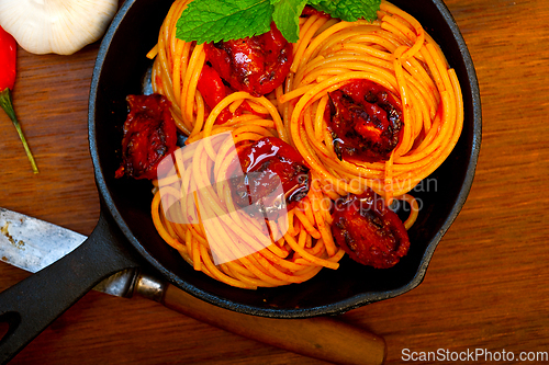 Image of italian spaghetti pasta and tomato with mint leaves