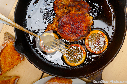 Image of pork chop seared on iron skillet