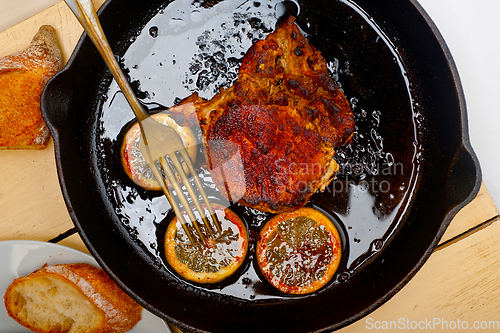 Image of pork chop seared on iron skillet