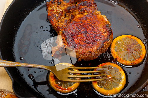 Image of pork chop seared on iron skillet