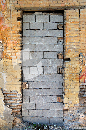 Image of bricked up door and chipped brick wall texture