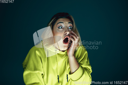 Image of Close up portrait of young crazy scared and shocked woman isolated on dark background