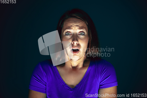 Image of Close up portrait of young crazy scared and shocked woman isolated on dark background