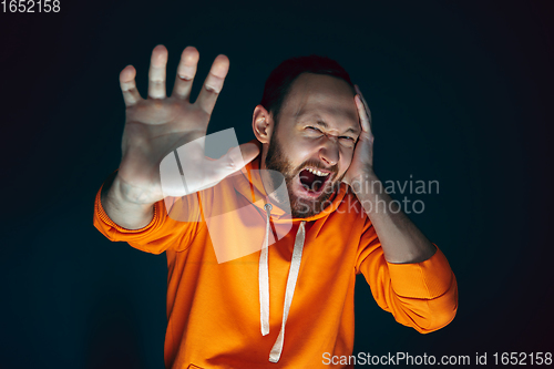 Image of Close up portrait of crazy scared and shocked man isolated on dark background