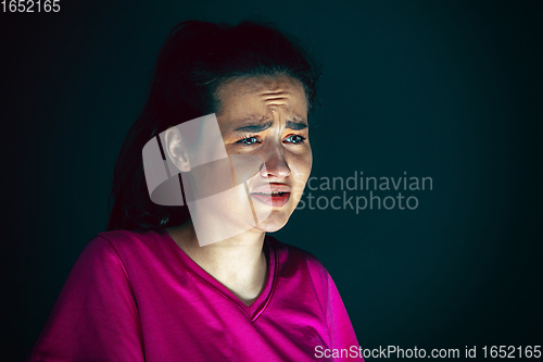 Image of Close up portrait of young crazy scared and shocked woman isolated on dark background