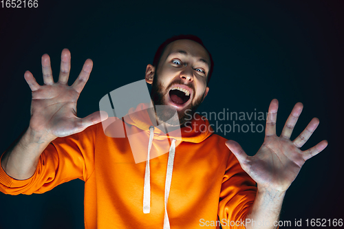 Image of Close up portrait of crazy scared and shocked man isolated on dark background