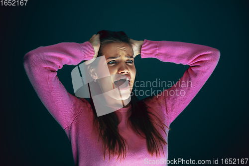 Image of Close up portrait of young crazy scared and shocked woman isolated on dark background