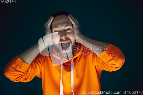 Image of Close up portrait of crazy scared and shocked man isolated on dark background