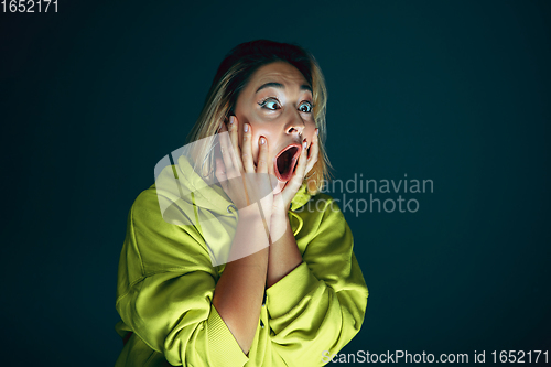 Image of Close up portrait of young crazy scared and shocked woman isolated on dark background