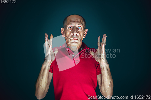 Image of Close up portrait of crazy scared and shocked man isolated on dark background