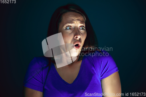 Image of Close up portrait of young crazy scared and shocked woman isolated on dark background