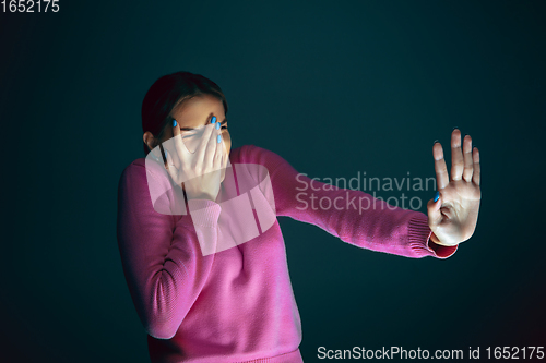 Image of Close up portrait of young crazy scared and shocked woman isolated on dark background