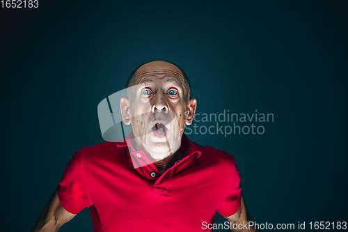 Image of Close up portrait of crazy scared and shocked man isolated on dark background