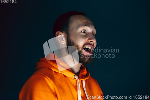 Image of Close up portrait of crazy scared and shocked man isolated on dark background