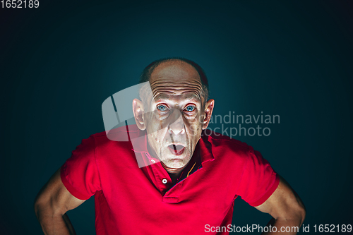 Image of Close up portrait of crazy scared and shocked man isolated on dark background