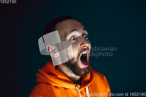 Image of Close up portrait of crazy scared and shocked man isolated on dark background