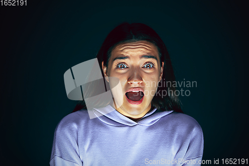 Image of Close up portrait of young crazy scared and shocked woman isolated on dark background