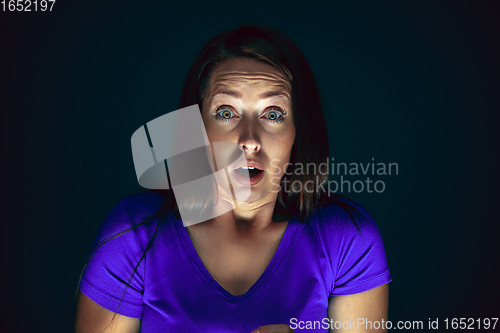 Image of Close up portrait of young crazy scared and shocked woman isolated on dark background