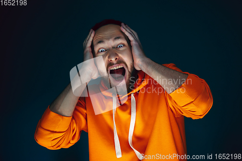 Image of Close up portrait of crazy scared and shocked man isolated on dark background