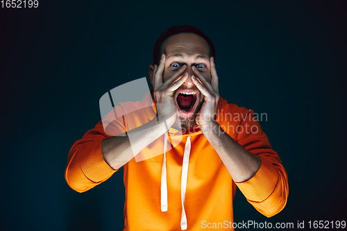 Image of Close up portrait of crazy scared and shocked man isolated on dark background