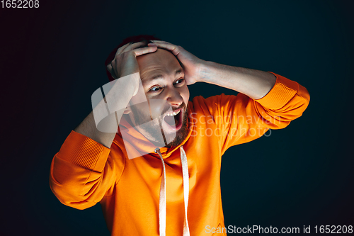 Image of Close up portrait of crazy scared and shocked man isolated on dark background