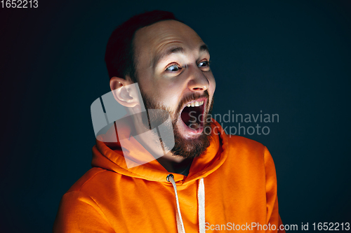 Image of Close up portrait of crazy scared and shocked man isolated on dark background