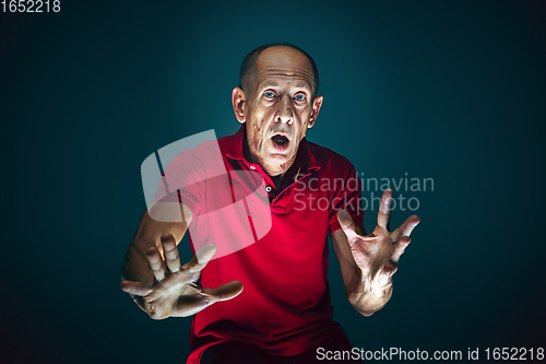 Image of Close up portrait of crazy scared and shocked man isolated on dark background