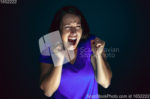 Image of Close up portrait of young crazy scared and shocked woman isolated on dark background