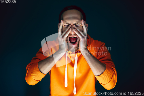 Image of Close up portrait of crazy scared and shocked man isolated on dark background