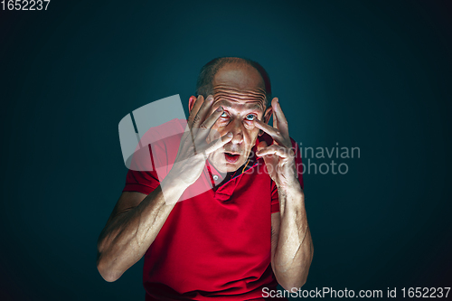 Image of Close up portrait of crazy scared and shocked man isolated on dark background