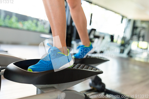 Image of Woman doing exercises in the gym on elliptical cross trainer