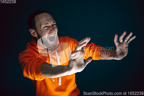 Image of Close up portrait of crazy scared and shocked man isolated on dark background