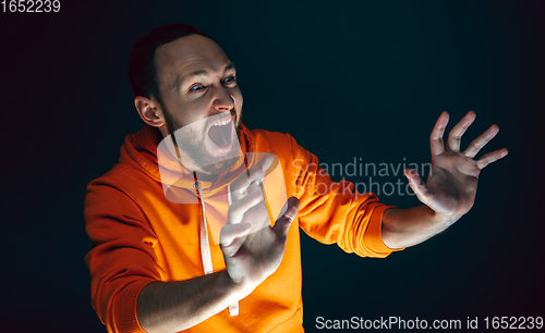 Image of Close up portrait of crazy scared and shocked man isolated on dark background